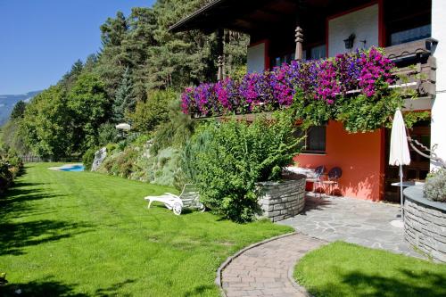 a house with flowers on the side of it at Residence Obermoarhof - Family Apartments with Pool & Playground in Vandoies