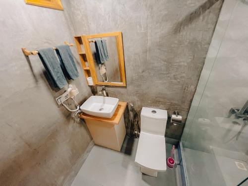 a bathroom with a toilet and a sink and a mirror at Mahchavaru Maldives in Mathiveri