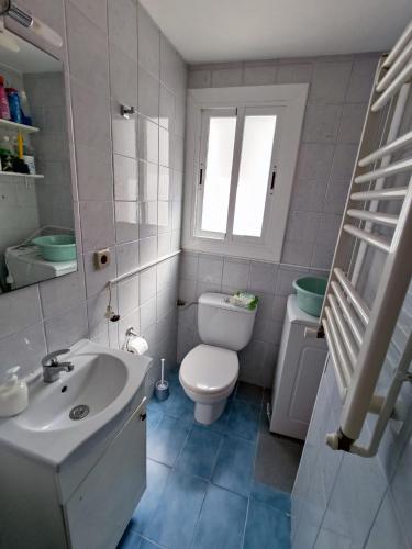 a white bathroom with a toilet and a sink at Calafell Beach.Primera línea.Céntrico. in Calafell