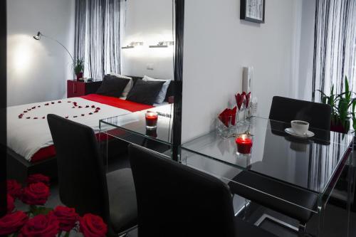 a room with a glass table and a bed with roses at Komorowski Luxury Guest Rooms in Kraków