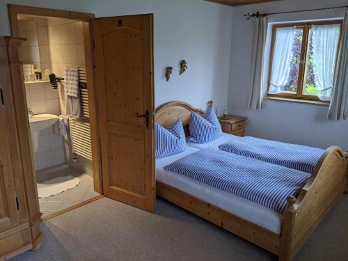 a bedroom with a bed and a shower and a window at Schusterbauer-Hof in Schleching