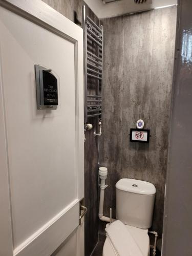 a bathroom with a toilet and a tv on the wall at The Residence - NO 8 in Edinburgh
