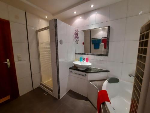 ein Bad mit einer Badewanne, einem Waschbecken und einer Dusche in der Unterkunft Apartment Schilcher in Oberau