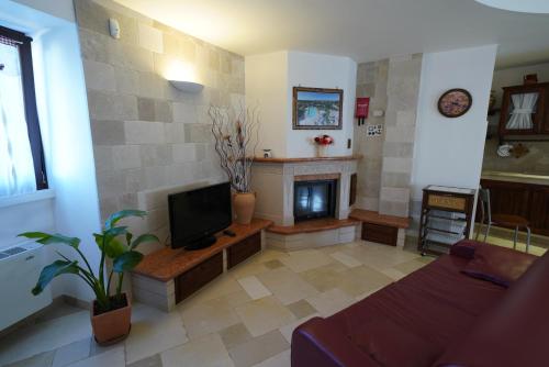 a living room with a tv and a fireplace at Villa Belvedere in Ostuni