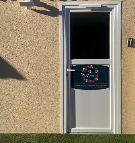 a white door with a sign on the side of a building at Le cocon in Dieppe