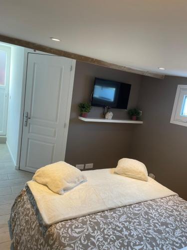 a bedroom with a bed and a tv on a wall at Le cocon in Dieppe
