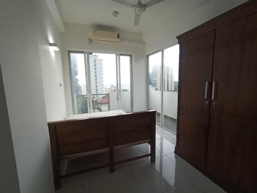 a bathroom with a wooden cabinet and a large window at 3 bedroom fully furnished apartment - Vel residencies in Colombo