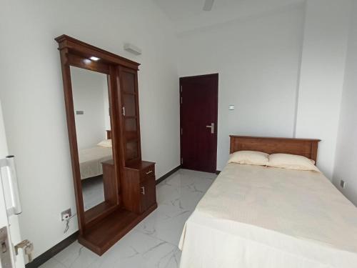 a bedroom with a bed and a mirror at 3 bedroom fully furnished apartment - Vel residencies in Colombo