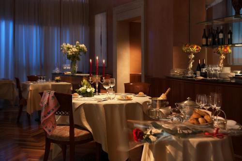 a dining room with two tables with white tablecloths at Hotel Cavour in Milan