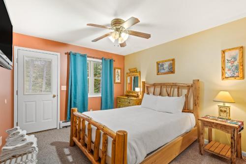 a bedroom with a bed and a ceiling fan at River Retreat in Brant Lake