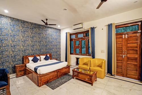 a bedroom with a bed and a chair at Jain Residency in Greater Noida