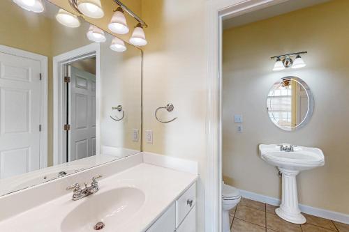 a bathroom with a sink and a toilet and a mirror at A Sweet Retreat in Huddleston