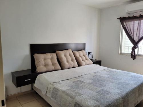 a bedroom with a large bed with a black headboard at Casa con pileta mirador de cabildo in La Punta