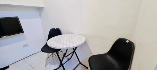 a room with two chairs and a table and a tv at 2 BR staycation beside Enchanted Kingdom in Santa Rosa