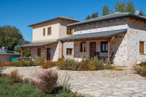 a house with a stone driveway in front of it at okakosolykos in Kostitsi