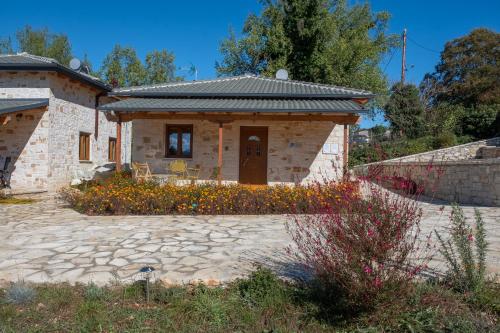 a small stone house with a stone patio at okakosolykos in Kostitsi