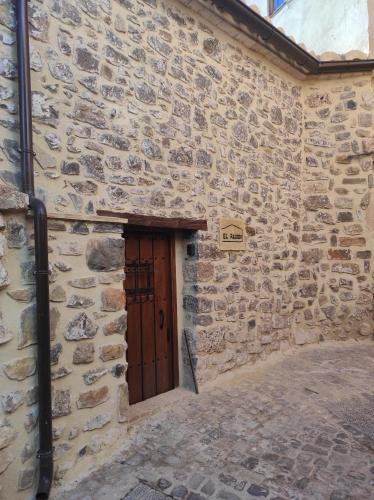 a stone building with a wooden door in it at Casa el Recreo in Jérica