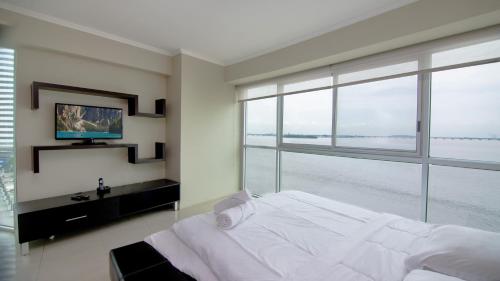 a bedroom with a large bed and a large window at Riverfront I 2, piso 4, suite vista al rio, Puerto Santa Ana, Guayaquil in Guayaquil