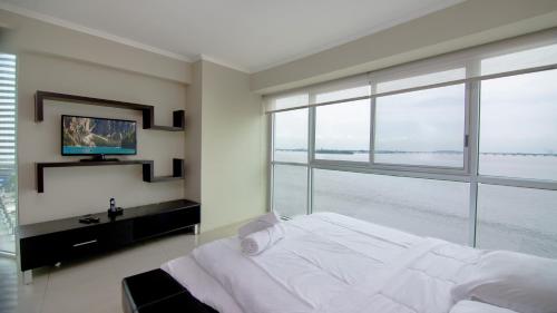 1 dormitorio con cama grande y ventana grande en Riverfront I 1, piso 4, suite vista al rio, Puerto Santa Ana, Guayaquil, en Guayaquil