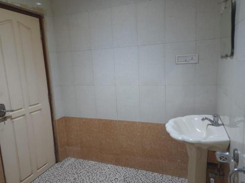 baño con lavabo, aseo y puerta en DP OBEROI RESIDENCY, en Ernakulam