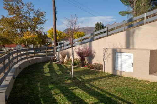 a fence next to a yard with a tree at Summit Guest House in Kalavrita