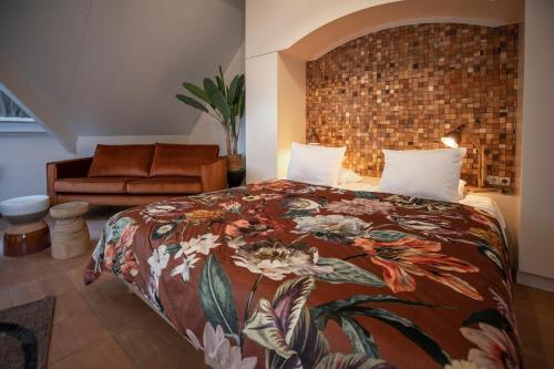 a bedroom with a bed with a floral bedspread at Bed & Bos de 14 Sterren in Den Burg