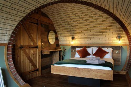 une chambre avec un lit dans un mur de briques dans l'établissement Hedgehogs View, à Rhayader