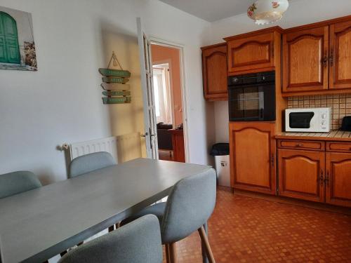 a kitchen with a table and chairs and a microwave at Le Croisic Brocéliande in Le Croisic