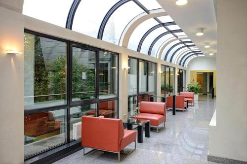 a hallway with chairs and windows in a building at Szmaragdowy Apartament nad Zalewem in Serock