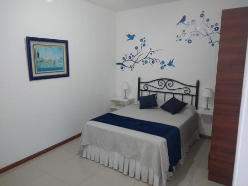 1 dormitorio con 1 cama con mariposas azules en la pared en Torre Murano I en Corrientes