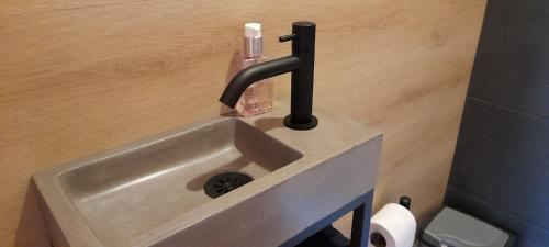 a sink in a bathroom with a soap bottle on it at Beemster b&b in Zuidoostbeemster