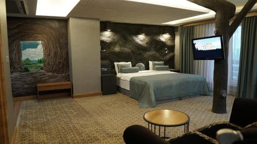 ブルサにあるGreen Prusa Hotelのベッド1台、薄型テレビが備わるホテルルームです。