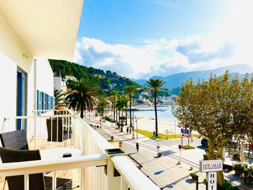 uma varanda com vista para uma praia e palmeiras em Hotel Miramar em Port de Sóller