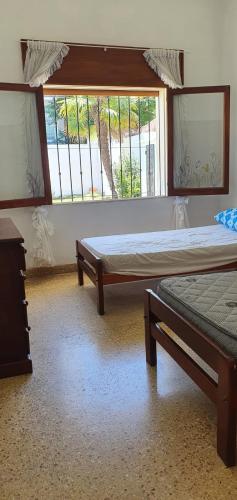 two beds in a room with two windows at Casa Grande Salta pleno centro de la ciudad in Salta