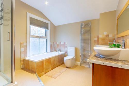 a bathroom with a tub and a toilet and a sink at City Centre 3 Bed - Perfect for Contractors and Families in Doncaster