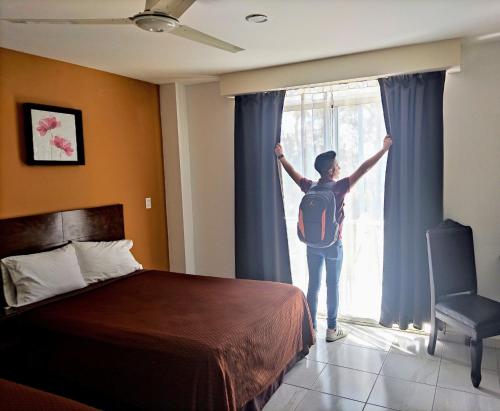 a person opening a window in a hotel room at Posada Del Carmen Aguascalientes in Aguascalientes