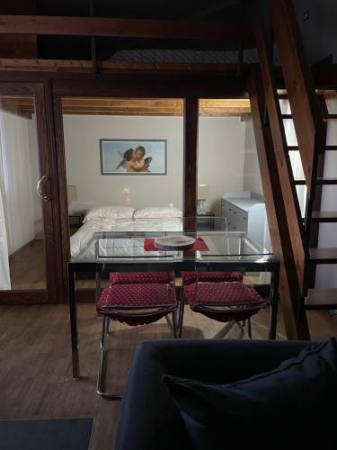 uma mesa de vidro e cadeiras num quarto com uma cama em OpenSpace Vista Panoramica em Abetone