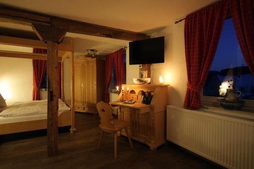 a bedroom with a bed and a desk with a chair at Hotel Restaurant Lindenhof in Bad Laasphe