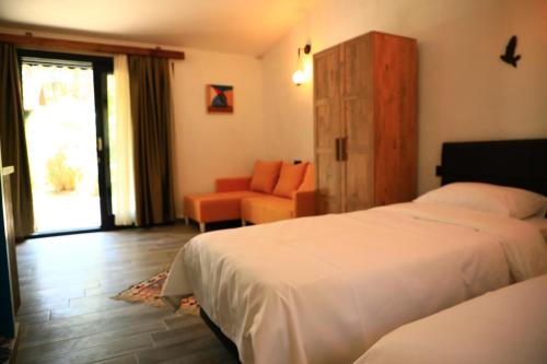 una habitación de hotel con 2 camas y una silla en Olympos Five Rooms Apart no 3, en Yazır