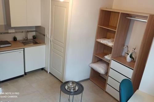 een kleine keuken met witte kasten en een kleine tafel bij Studio meublée avec sanitaires douche kitchenette in Angers