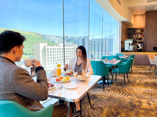 a man and woman sitting at a table in a restaurant at Safi Royal Luxury Metropolitan in Monterrey