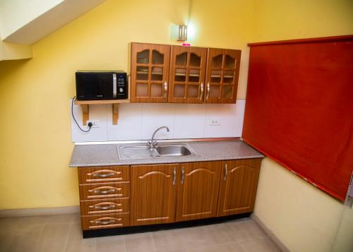 a small kitchen with a sink and a microwave at Airside Hotel in Accra