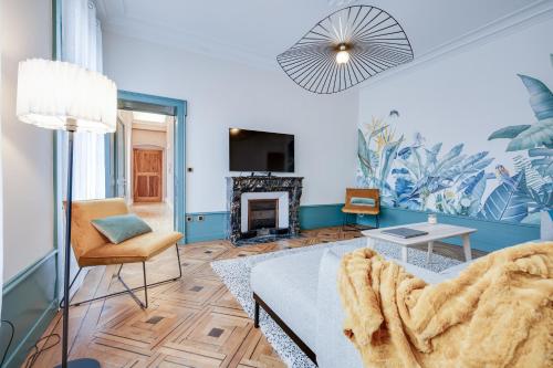 salon z kanapą i kominkiem w obiekcie Grand appartement 8 personnes terrasse privative hyper centre calme w mieście Lons-le-Saunier