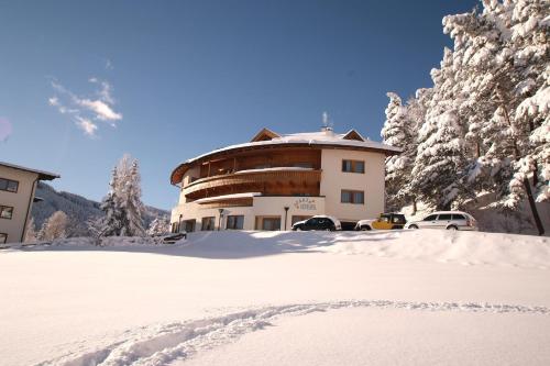 a building in the snow with cars parked in front at Apart Ideal Serfaus in Serfaus