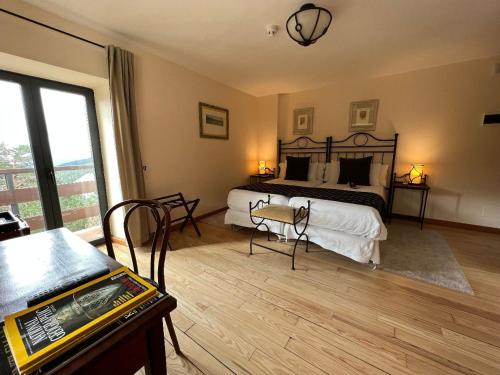 a bedroom with a bed and a desk with a table at Corzo Hotel in Cercedilla