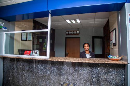 a woman standing behind a counter in an office at Airside Hotel in Accra