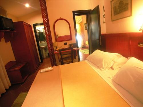 a bedroom with a large bed and a mirror at Hotel Toledo in Naples