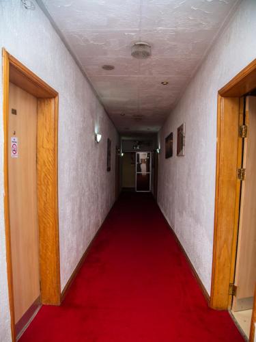 a long corridor with a red carpet in a hallway at Airside Hotel in Accra