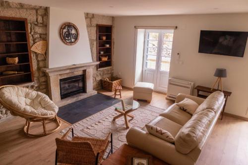 a living room with a couch and a fireplace at Casal dos Netos in Penhas da Saúde