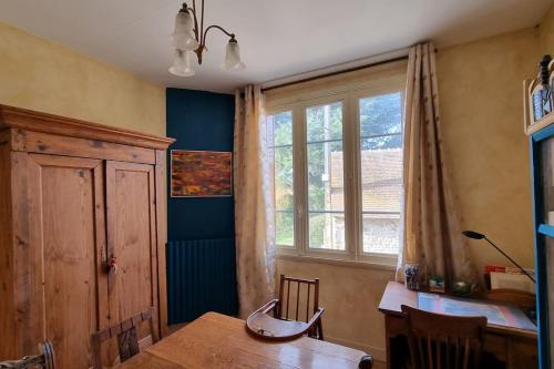 a dining room with a table and a window at Les Noyers Monestois entre Cher et Canal de Berry in Mennetou-sur-Cher